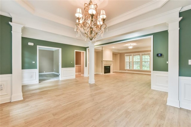 6714 Amherst Dr, Hoschton, GA 30548 - unfurnished living room featuring decorative columns, ornamental molding, a fireplace with flush hearth, light wood finished floors, and a wainscoted wall