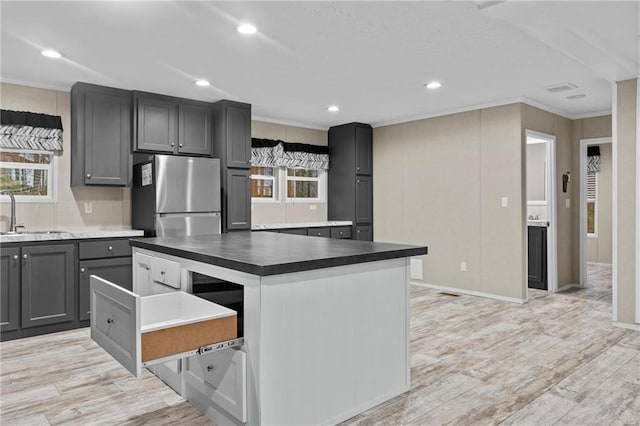 150 Saphire Hill Ct, Clarkesville, GA 30523 - kitchen with freestanding refrigerator, a sink, crown molding, dark countertops, and a kitchen island