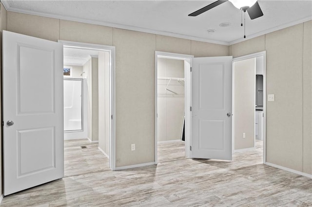 150 Saphire Hill Ct, Clarkesville, GA 30523 - unfurnished bedroom featuring light wood finished floors, a spacious closet, a closet, a ceiling fan, and crown molding