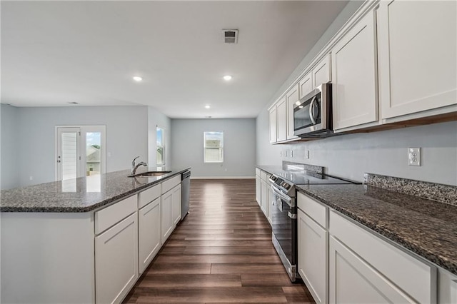 31 Mccall Way, Monroe, GA 30655 - kitchen with stainless steel appliances, dark wood-type flooring, an island with sink, recessed lighting, and dark stone counters