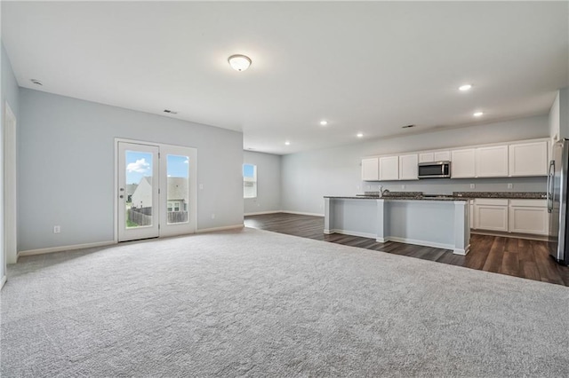 31 Mccall Way, Monroe, GA 30655 - kitchen featuring dark countertops, stainless steel appliances, open floor plan, recessed lighting, and white cabinets