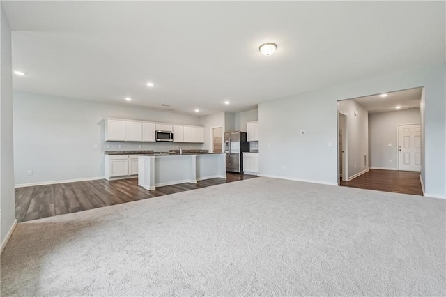 31 Mccall Way, Monroe, GA 30655 - kitchen with open floor plan, appliances with stainless steel finishes, dark carpet, dark countertops, and recessed lighting
