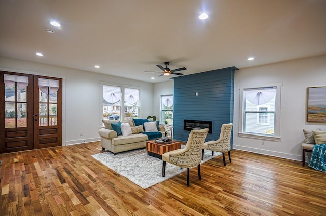 living room with hardwood / wood-style flooring, plenty of natural light, and a large fireplace