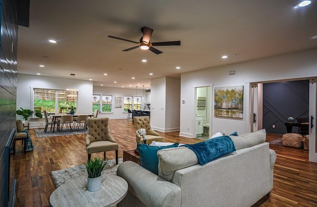 living room with dark wood-type flooring and ceiling fan