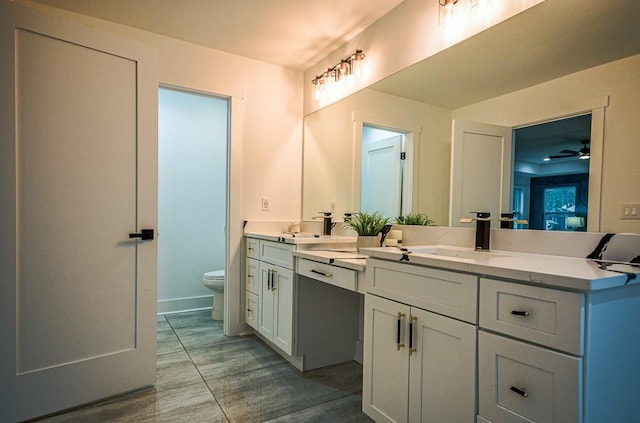 bathroom with vanity, ceiling fan, and toilet