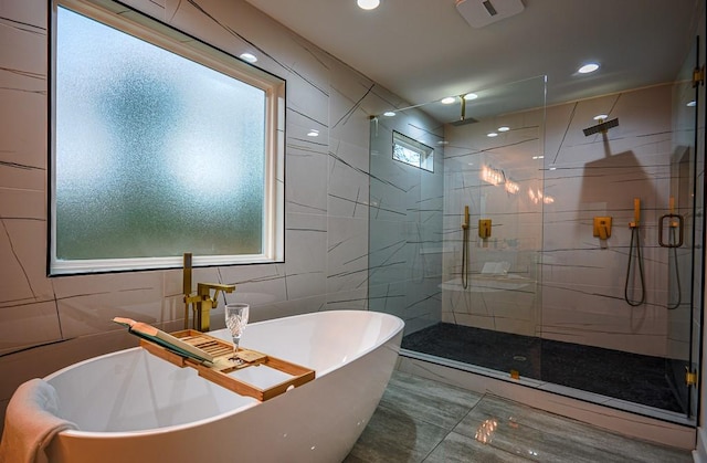 bathroom featuring separate shower and tub and tile walls