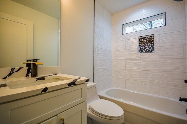 full bathroom featuring tiled shower / bath, vanity, and toilet