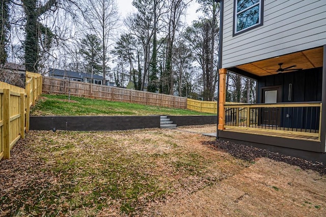 view of yard with a wooden deck and ceiling fan