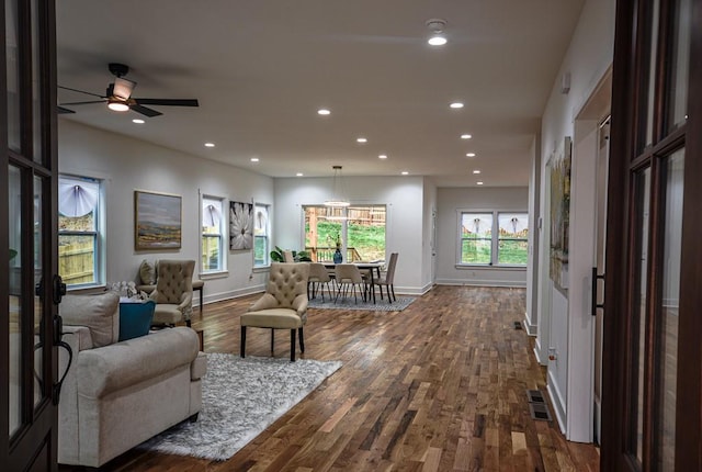 living room featuring dark hardwood / wood-style flooring and ceiling fan