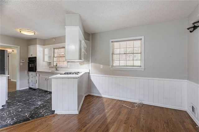 1753 Dodson Dr SW, Atlanta, GA 30311 - kitchen with wainscoting, white cabinetry, a sink, and black oven