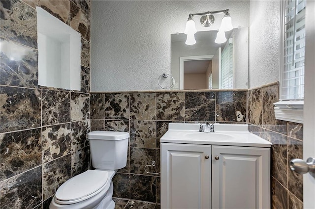 1753 Dodson Dr SW, Atlanta, GA 30311 - bathroom featuring a textured wall, vanity, tile walls, and toilet