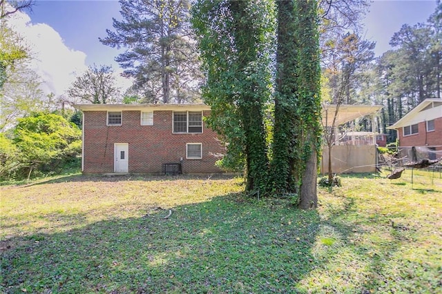 1753 Dodson Dr SW, Atlanta, GA 30311 - rear view of house featuring central AC unit, brick siding, fence, and a lawn