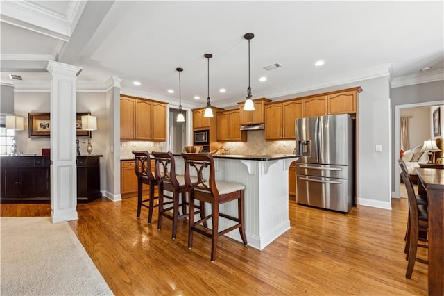4492 Arbor Crest Ct, Suwanee, GA 30024 - kitchen with stainless steel fridge, ornate columns, built in microwave, a kitchen breakfast bar, and light wood-type flooring