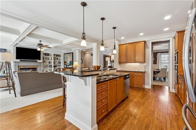 4492 Arbor Crest Ct, Suwanee, GA 30024 - kitchen featuring appliances with stainless steel finishes, a breakfast bar, a ceiling fan, light wood finished floors, and crown molding