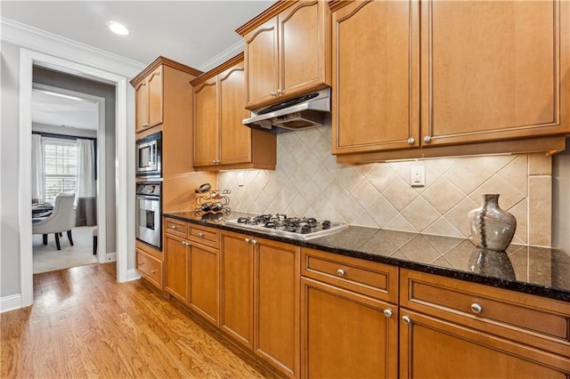 4492 Arbor Crest Ct, Suwanee, GA 30024 - kitchen featuring under cabinet range hood, stainless steel appliances, dark stone counters, light wood-type flooring, and brown cabinets