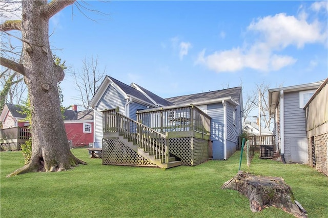 rear view of house featuring a wooden deck, stairs, and a yard