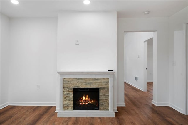 unfurnished living room featuring a fireplace and dark wood-type flooring