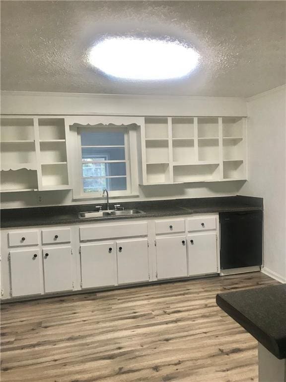 kitchen with white cabinetry, light hardwood / wood-style floors, sink, and a textured ceiling