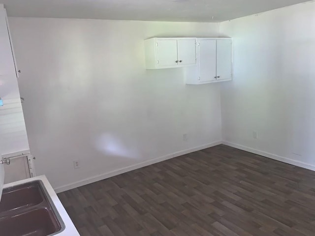 empty room with dark hardwood / wood-style floors and sink