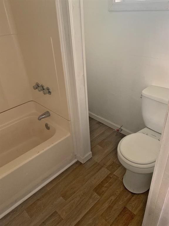 bathroom featuring shower / bath combination, toilet, and hardwood / wood-style floors