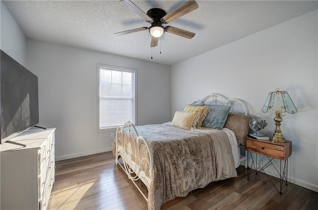 bedroom with a textured ceiling, ceiling fan, wood finished floors, and baseboards