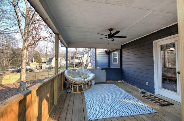 wooden terrace featuring a residential view, fence, and a ceiling fan