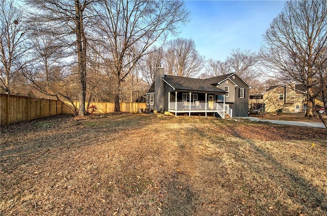 view of front of property featuring a fenced backyard, a chimney, and a front lawn