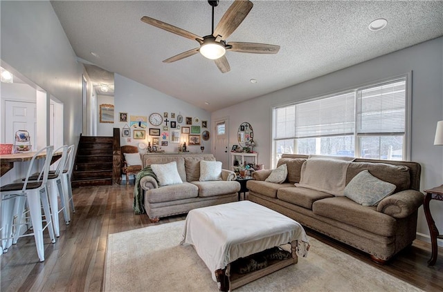 living room with lofted ceiling, a textured ceiling, dark wood-style flooring, a ceiling fan, and stairway