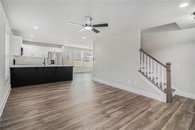 kitchen with backsplash, white cabinets, dark wood-type flooring, and stainless steel refrigerator with ice dispenser