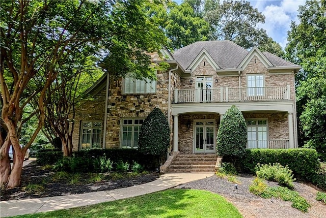 view of front of home with a balcony and french doors