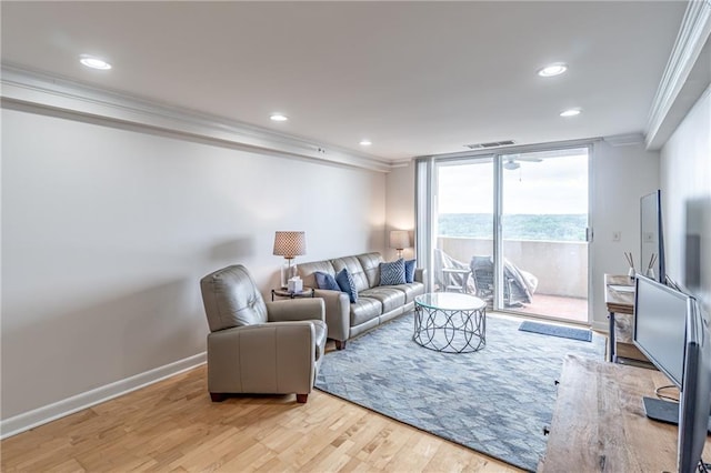 living area with visible vents, ornamental molding, wood finished floors, recessed lighting, and baseboards