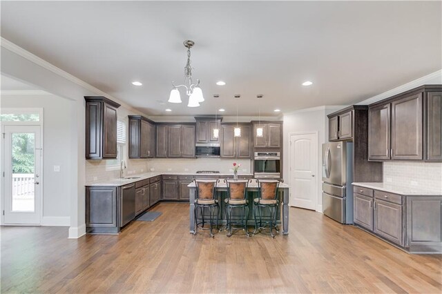 4240 Summer Breeze Way, Buford, GA 30518 - kitchen with appliances with stainless steel finishes, dark brown cabinets, a kitchen island, a chandelier, and light countertops