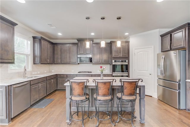 4240 Summer Breeze Way, Buford, GA 30518 - kitchen with appliances with stainless steel finishes, dark brown cabinetry, ornamental molding, a center island, and a sink