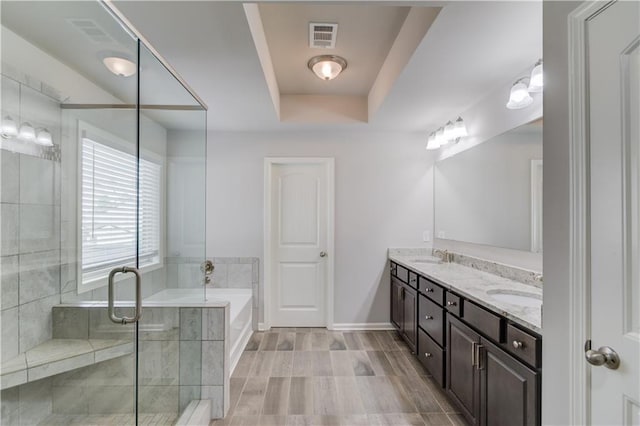 4240 Summer Breeze Way, Buford, GA 30518 - full bathroom with a tray ceiling, double vanity, a bath, a shower stall, and baseboards