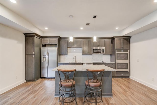 4240 Summer Breeze Way, Buford, GA 30518 - kitchen with appliances with stainless steel finishes, baseboards, a center island, a sink, and tasteful backsplash