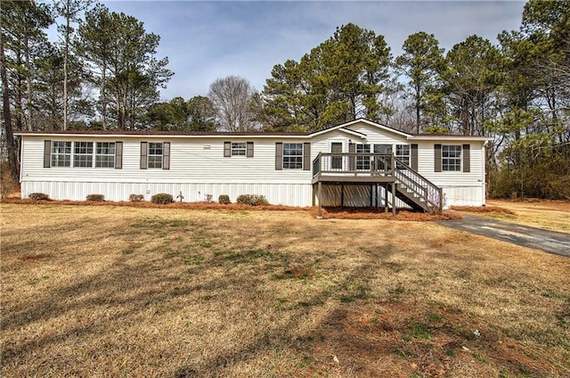 manufactured / mobile home featuring stairs, a front lawn, and a wooden deck