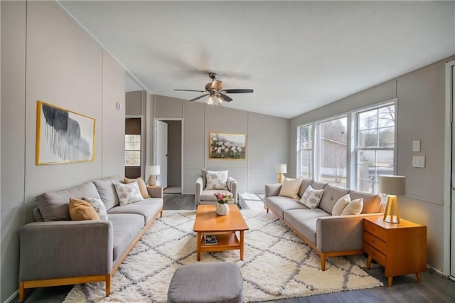 living area featuring a ceiling fan, vaulted ceiling, and wood finished floors