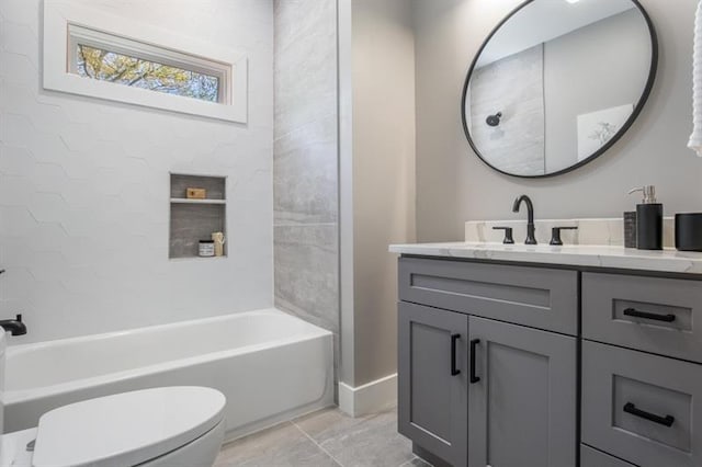 full bathroom with vanity, tiled shower / bath, and toilet