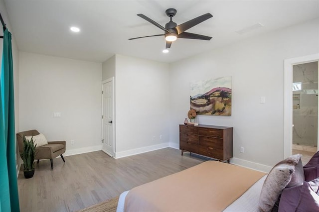 bedroom featuring ceiling fan, light hardwood / wood-style floors, and ensuite bath