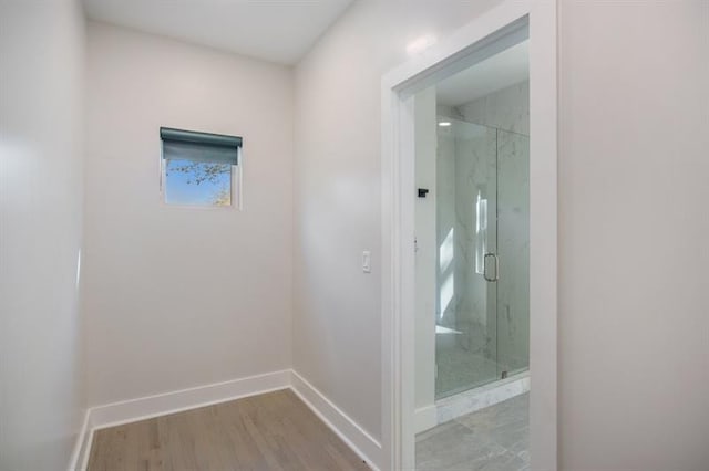 bathroom featuring an enclosed shower and hardwood / wood-style flooring