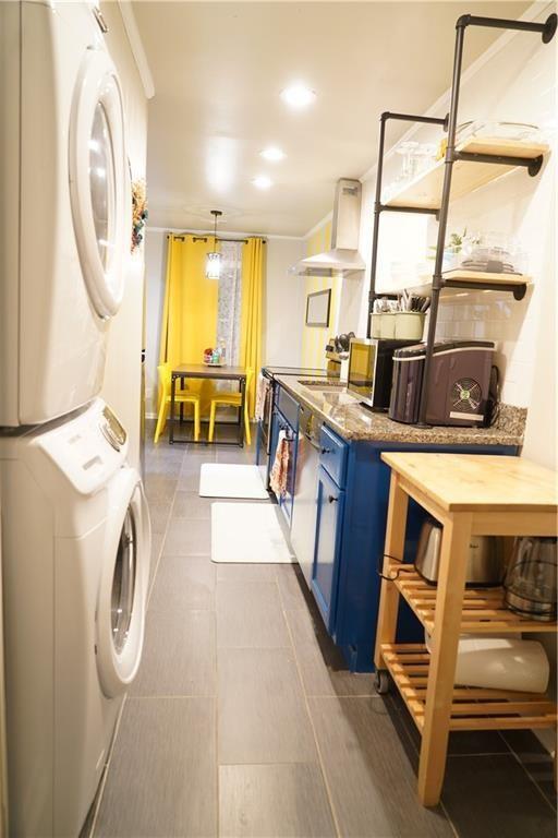 1452 Mercer Ave, Atlanta, GA 30337 - laundry room with estacked washer and dryer, recessed lighting, and dark tile patterned floors