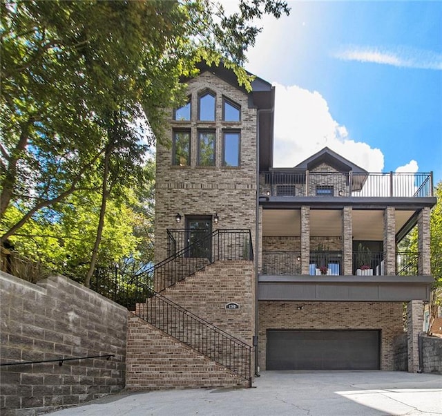1260 Monroe Dr NE, Atlanta, GA 30306 - view of front of house with a balcony, a garage, concrete driveway, and brick siding