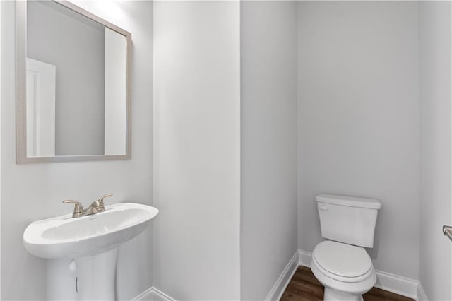 bathroom featuring hardwood / wood-style flooring, sink, and toilet