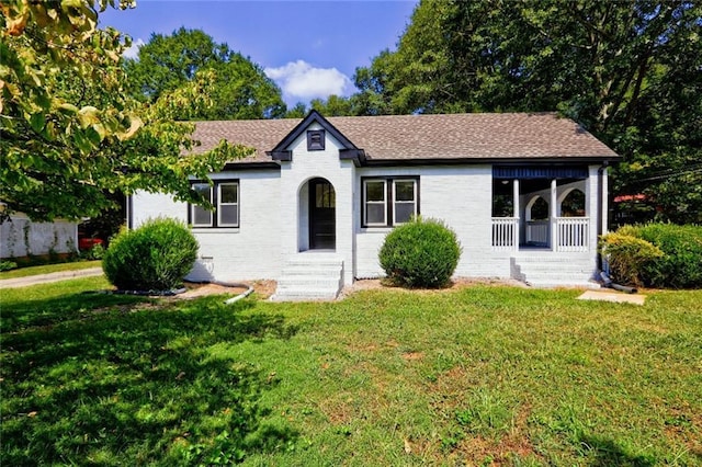 single story home with covered porch and a front yard