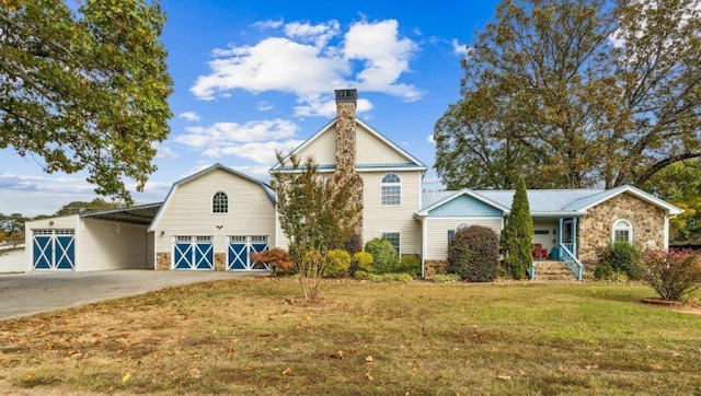 view of front of house with a front lawn, driveway, stone siding, and covered porch