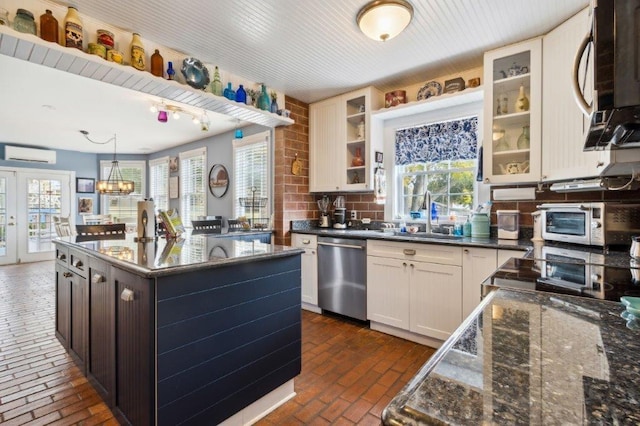 kitchen featuring a sink, brick floor, an AC wall unit, a center island, and stainless steel dishwasher