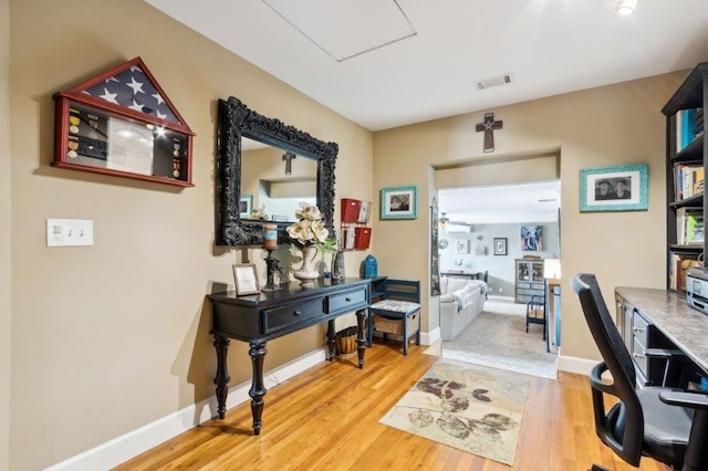office space with visible vents, baseboards, and wood finished floors