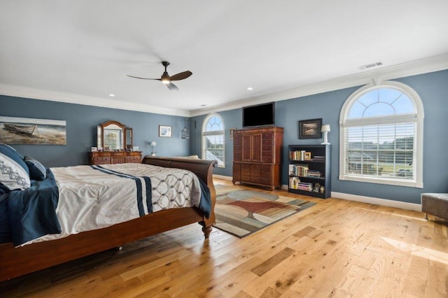 bedroom featuring visible vents, light wood-style flooring, crown molding, and baseboards