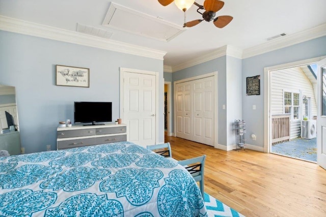 bedroom with visible vents, ornamental molding, wood finished floors, and attic access