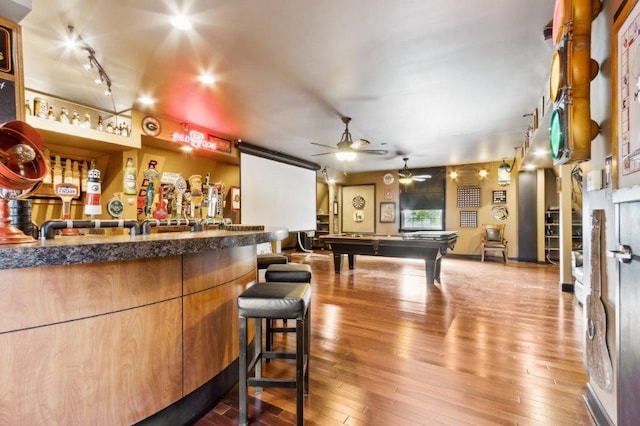 bar featuring billiards, ceiling fan, a community bar, and hardwood / wood-style flooring